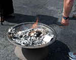 hand of man throwing paper into fire